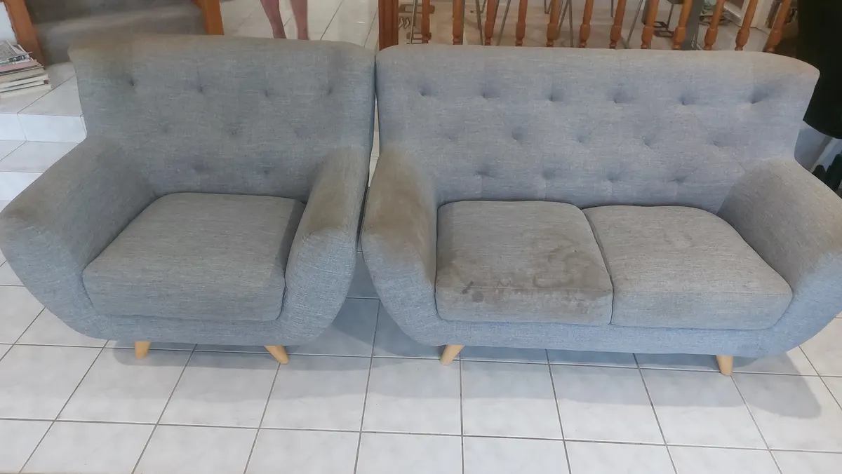 A grey fabric lounge suite with soiled seat cushions and arms, before cleaning